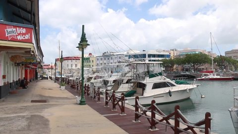 Bridgetown, Barbados - April 27, 2021: Video of a Sandals company yacht docked in the city's turquoise water harbour during the COVID-19 pandemic. Bright sunny day, tied up beside other boats.