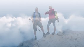Happy caucasian senior couple on top of mountains over fast moving clouds. active outdoor retirement lifestyle concept digitally generated video.