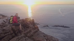Happy caucasian senior woman hiking by the coast over sunset. active outdoor retirement lifestyle concept digitally generated video.