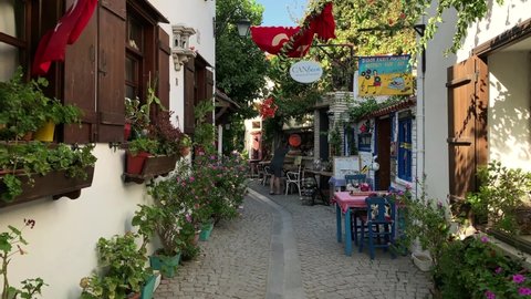 IZMIR, TURKEY - CIRCA AUGUST, 2020: Footage of narrow street, traditional, old historical houses and restaurants in famous, touristic Aegean town called "Sigacik". It is a village of Seferihisar