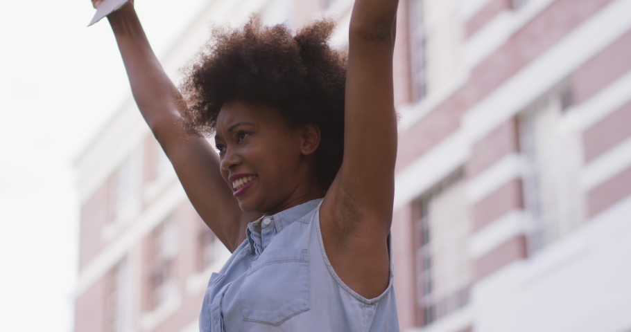 African american woman holding placard shouting during protest. equal rights and justice protestors on demonstration march.