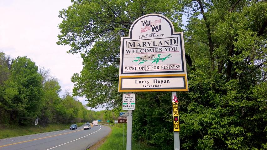  Maryland Welcomes You road sign on the scenic byway US Route 15 at the border of Maryland and Virginia.  It has MD flag and says open for business. 