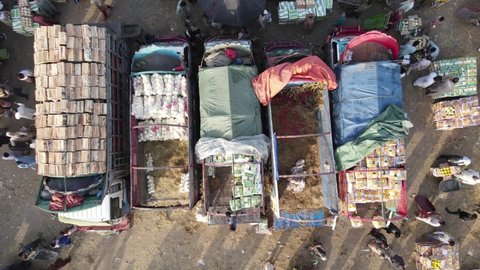 Islamabad, Pakistan - April 14,2021 
 Zoom out aerial shot of items being loaded in trucks in a busy market
