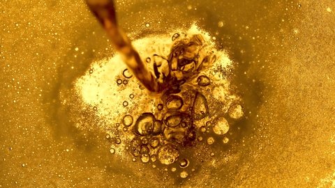 Top view of light beer being poured into a glass. Craft beer is poured into a mug forming foam and bubbles close up. Freshness and foam. Beautiful beer textured background for advertising. Slow motion