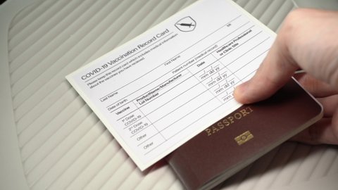 Placing vaccination record card and passport on the table