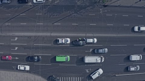 Two cars accident: gray and black one - zoom in drone shot of two cars on the road. Cars go around the scene of an accident.