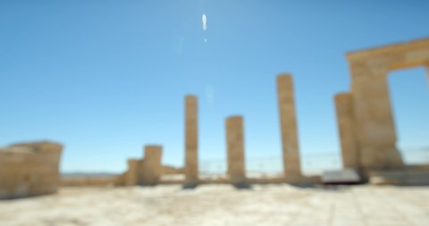 4K pan shot the Temple of Oboda at the Avdat Ruin in the Negev Desert in southern Israel, site of a ruined Nabataean city on a sunny day with a blue sky, archaeology, stony archway and pillars