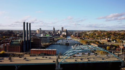 Providence, RI - October 21st, 2020: Traffic zooms across the I-95 Providence River Bridge Iway as clouds float across the blue sky above downtown and the  Manchester Street Power Station smokestacks.