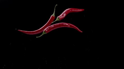 Fresh flying chili peppers on dark background