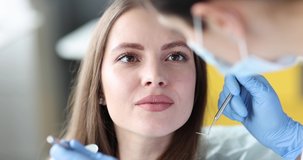 Dentist examining teeth of young woman patient 4k movie