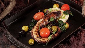 Octopus dishes with beautiful decor. Slow motion picture of food. Restaurant dish.