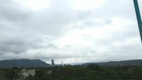 Timelapse video of the moving clouds. Acc cement factory, cloudy sky at just after rainy day, A beautiful natural background hill, green tree and morning light.
