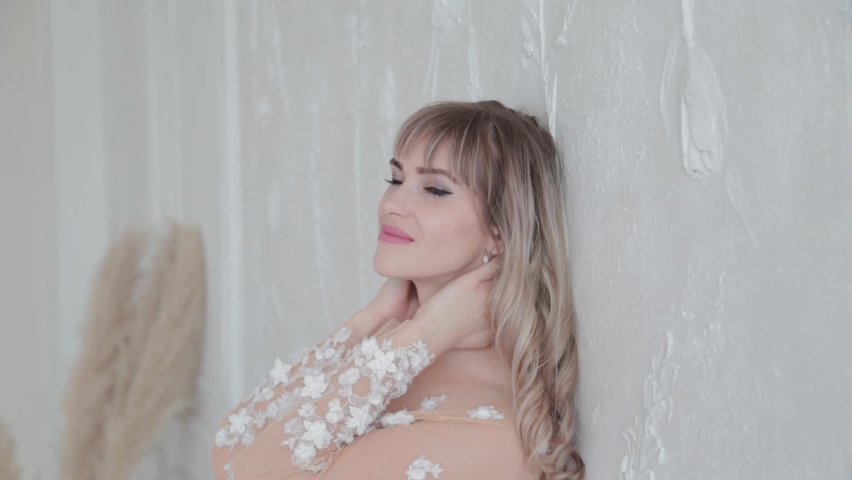 Beautiful woman in dress in white room.