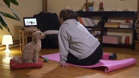 Woman exercising and watching online workout video. Recreation at home