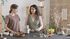 Medium PAN shot of two young good-looking women making scrub by themselves, using blender for grinding coffee beans - Powered by Shutterstock - Get 15% off with code: PIKWIZARD15