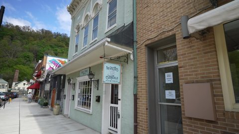 Berkeley Springs, WV, USA - 04 25 2021: Camera pushing showing small business storefronts in small town, rural, Berkeley Springs, WV in the Appalachian mountains.