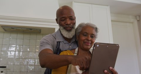 African american senior couple having a video call on digital tablet in the kitchen at home. retirement senior couple lifestyle living concept