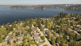 Cinematic aerial drone footage of downtown Mercer island, residential and commercial areas, luxury, beachfront homes in Beaumont by Lake Washington, with Bellevue skyscrapers in the background