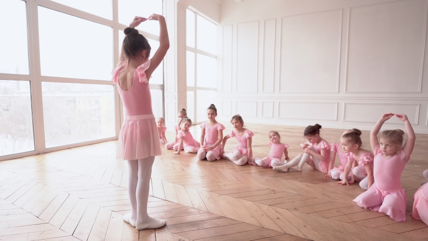 Girls dancers in ballet school learns to dance. Little Ballerinas in training in pink dancing suit. Children's ballet school. School of ballet. Royalty-Free Stock Footage #1071616228