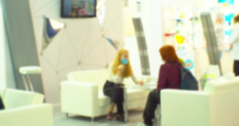 blurred background on a business theme.blurred silhouettes of businessmen.two women communicate behind a table at a business meeting.