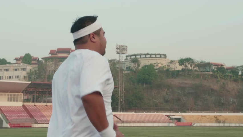 Fat Man Running at Stadium
