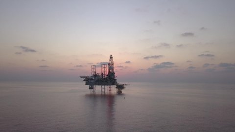 Aerial view of offshore drilling rig during sunrise - oil and gas industry