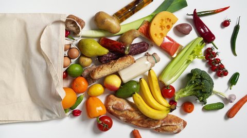 Grocery bag with fruits, vegetables, bread, bottled beverages. Vertical footage. Top View. Stop Motion