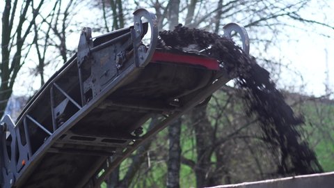 4k stock video footage of process of repairing of asphalt pavement of road. Road cold milling machine removes old asphalt loading it into dump truck. Construction of new road or sidewalk