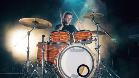 Drum set, drum kit in dark, drummer plays a concert. A man is enjoying his drumming rehearsals