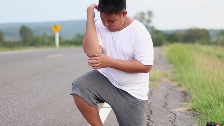 Asian boy Arm pain after exercising outdoors Jogging when the sun is about to set Exercise for health | Shutterstock HD Video #1071640243