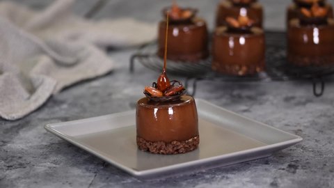 Mini mousse pastry dessert covered with chocolate mirror glaze. Modern european cake.