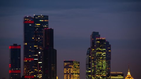 Timelapse: modern tall buildings, skyscrapers from evening to night, gets dark. Architecture, corporate, cityscape, financial, business, urban, time lapse cityscape concept