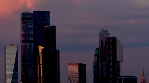 Timelapse - view on modern tall buildings, skyscrapers - Moscow city downtown - from day to night, gets dark. Architecture, corporate, financial, business, urban, time lapse, cityscape concept