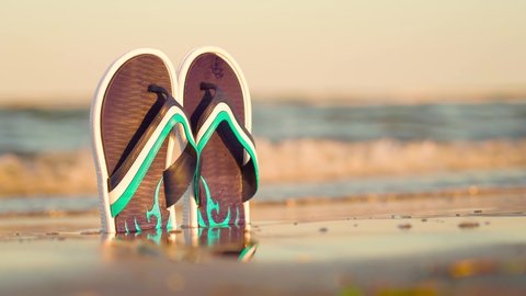 Flip flops illuminated by the setting sun at the sea