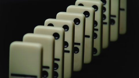 Video of falling domino elements - domino effect on black
