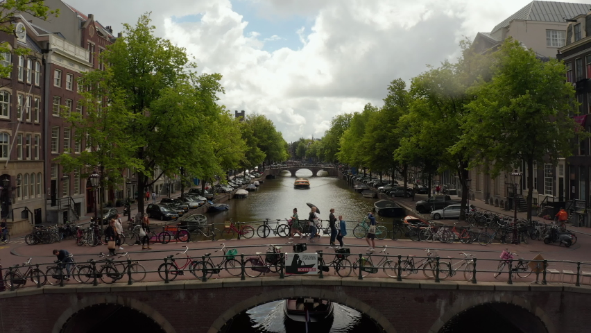 Amsterdam, Netherlands Canal Bridge with a Group of Tourists wearing Masks, Cityscape Crane Aerial in 2020
