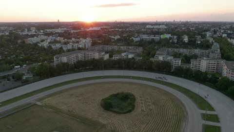 Aerial Establishing Shot of Harness Horse Race on dirt track in Sunset light, Drone perspective from above