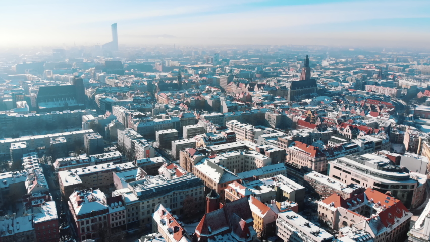 Aerial view of Market Square in the old city of Wroclaw. Landscape panorama of Europe. Skyscrapers touching the sky. Footage is made during the daytime. Blue sky with a pinch of orange in the Royalty-Free Stock Footage #1071695497