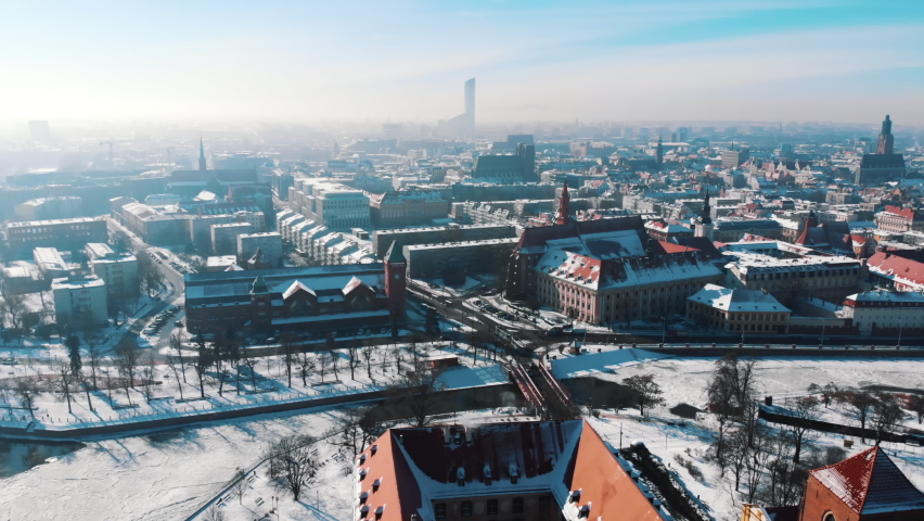 Aerial view of Market Square in the old city of Wroclaw. Landscape panorama of Europe. Skyscrapers touching the sky. Vehicles running on the street. Blue sky with a pinch of orange in the background. 
