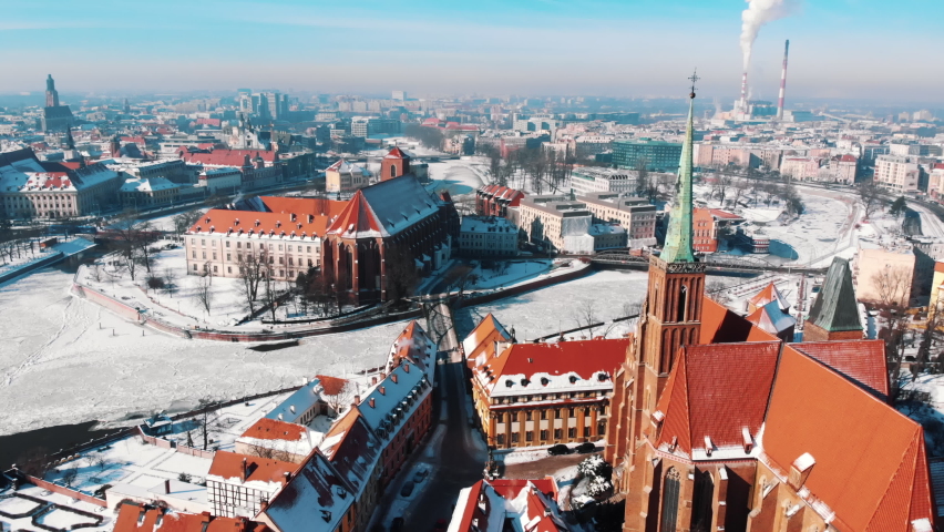 Aerial View of the historic city center - Stary Rynek square and old market square in the city of Wroclaw, Poland. Smoke coming out of the chimneys from the power plant. Winter season. 