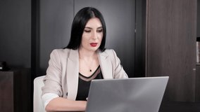 Business woman with black hair and red lips having video call with foreign partner at meeting room girl using laptop for chatting conference calling looking at pc screen at remote workplace