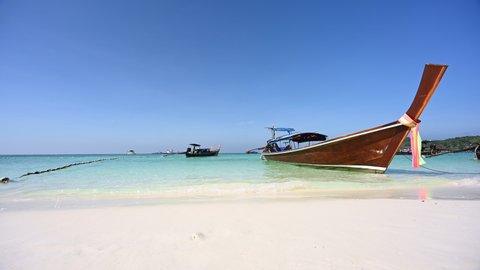 Footage 4k B-roll of thai long tail boats On the beach at Koh Lipe thailand with Crystal clear shallow water during sunny summer weather