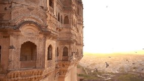 Slow motion video of some pigeons flying over the Udaipur City Palace during a stunning sunset. Udaipur, Rajasthan, India.