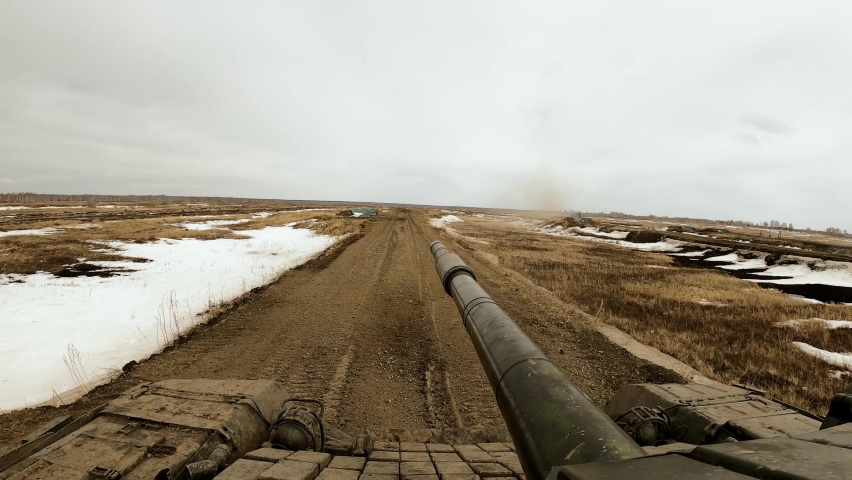 Military tank shoots from a cannon, tank biathlon takes place in a field in winter, after the shot remains a lot of smoke. Russia, Chelyabinsk region, Chebarkul. 4K resolution video, slow motion.