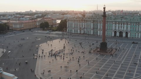 Aerial footage of Palace square and Alexander Column at sunset, the angel with cross, the Winter Palace, the Hermitage, Admiralty building, little people