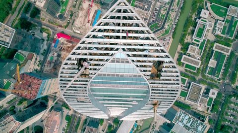 Suzhou, China - September 04, 2020: Aerial close-up tilt view of a skyscaper under construction with reflections on the glass windows in a business district of Suzhou, China. IFS building.