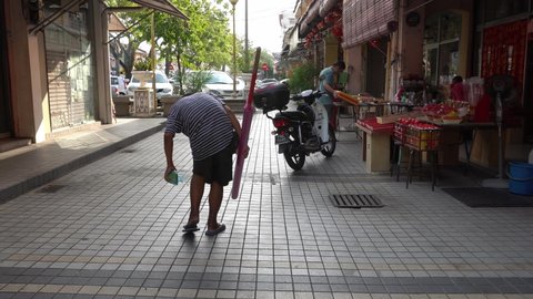 George Town, Penang, Malaysia - Jan 18 2020: A man bring large joss stick walk at street.