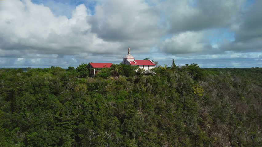 Aerial view tilting over the Chapelle Notre Dame de Lourdes, in Lifou, New Caledonia - rising, drone shot