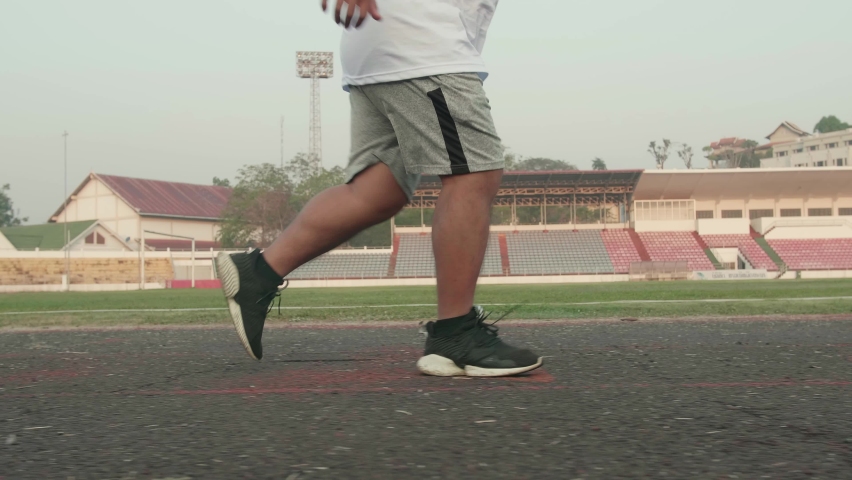 Legs Of Overweight Man Running At Stadium
