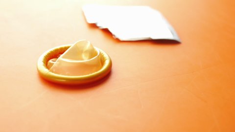 close up of condom on orange backgrund 